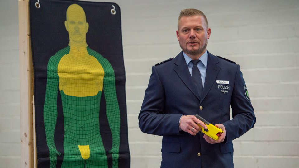 Pilot Projekt der NRW-Polizei: Erste Polizeibehörden testen Distanzelektroimpulsgeräte, Polizist erklärt das Gerät
