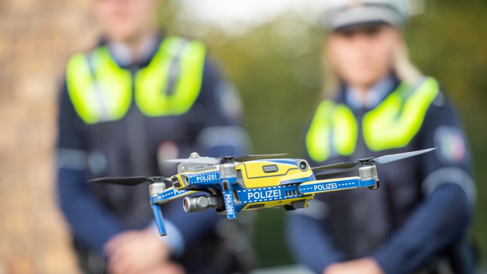 Einführung Drohnen Polizei NRW - Flug Drohne mit Polizisten im Hntergrund