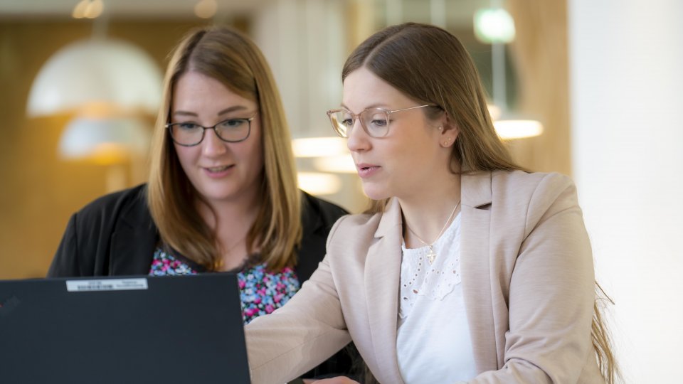 Zwei Frauen arbeiten gemeinsam am Laptop