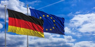 Germany and European Union waving flags on blue sky background