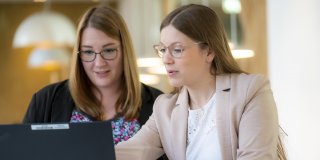 Zwei junge Frauen arbeiten gemeinsam am Notebook