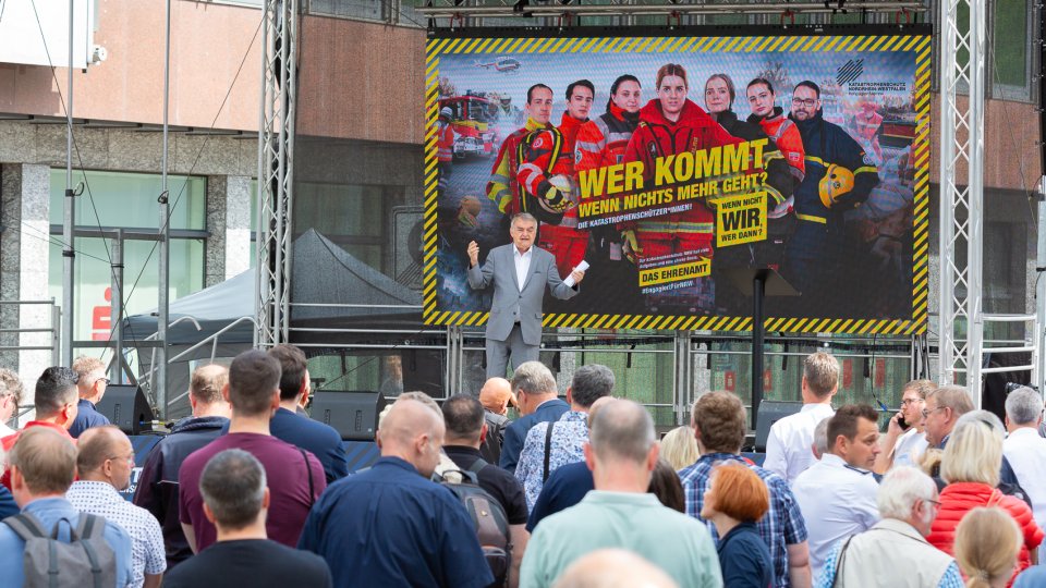 Innenminister Herbert Reul steht vor zahlreichen Passanten auf der Bühne.
