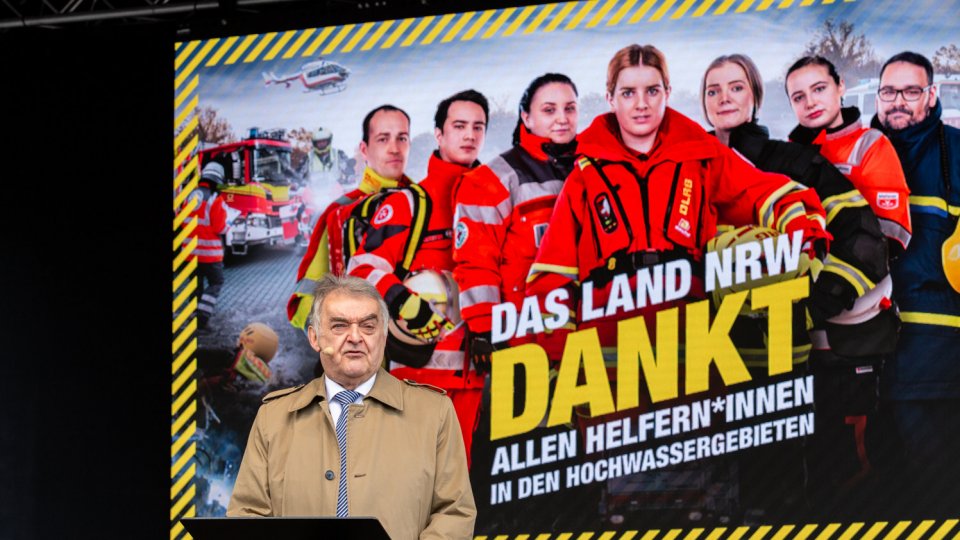 Minister Reus auf der Bühne vor Plakat "Das Land NRW dankt"