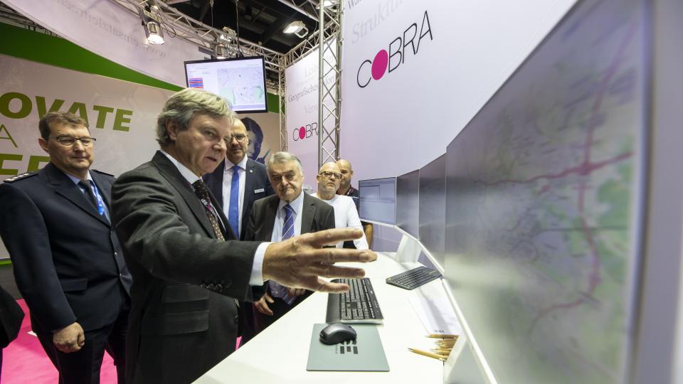 Minister Herbert Reul beucht verschiedene Stände auf der PMR Expo