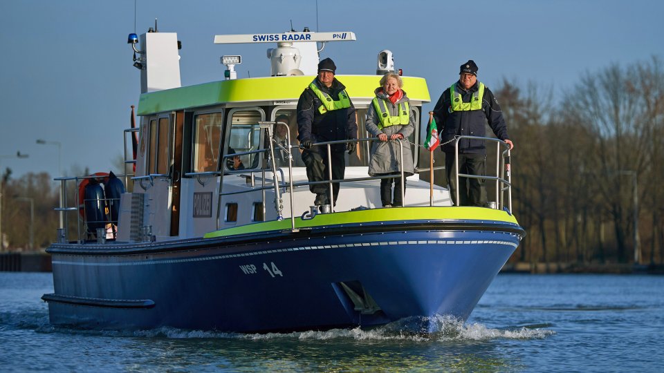 Boot der Wasserschutzpolizei mit drei Personen (zwei Polizisten) vorne am Bod stehend