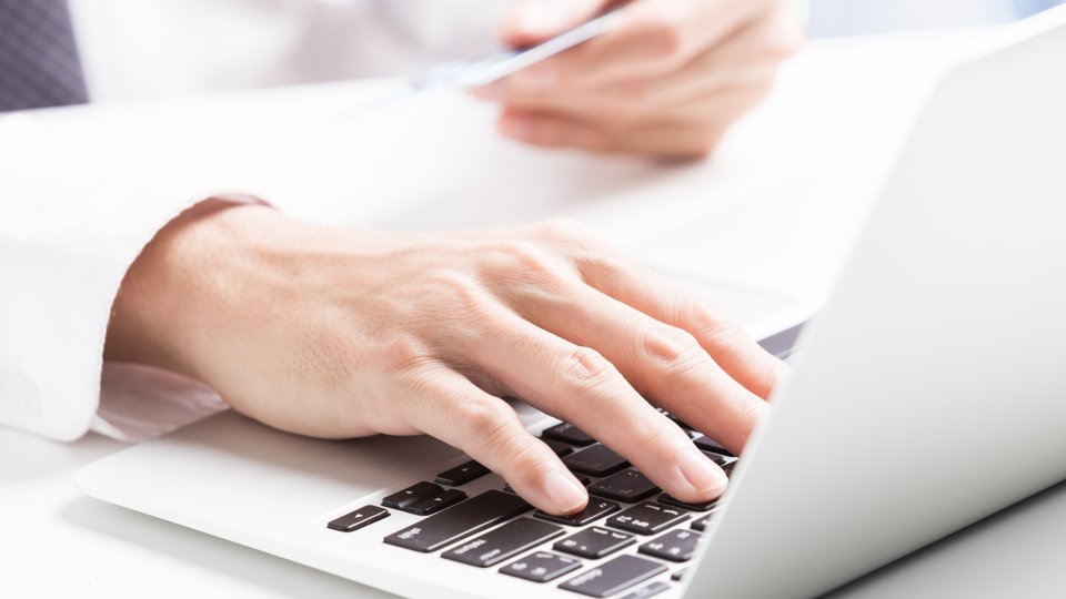 E-Rechnung, Hand an Laptop
