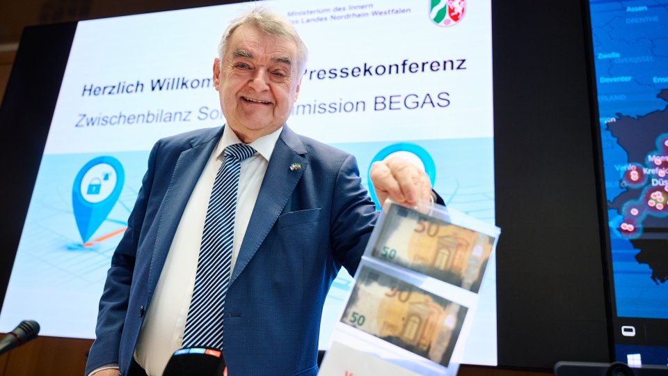 Innenminister Herbert Reul mit Geldnoten
