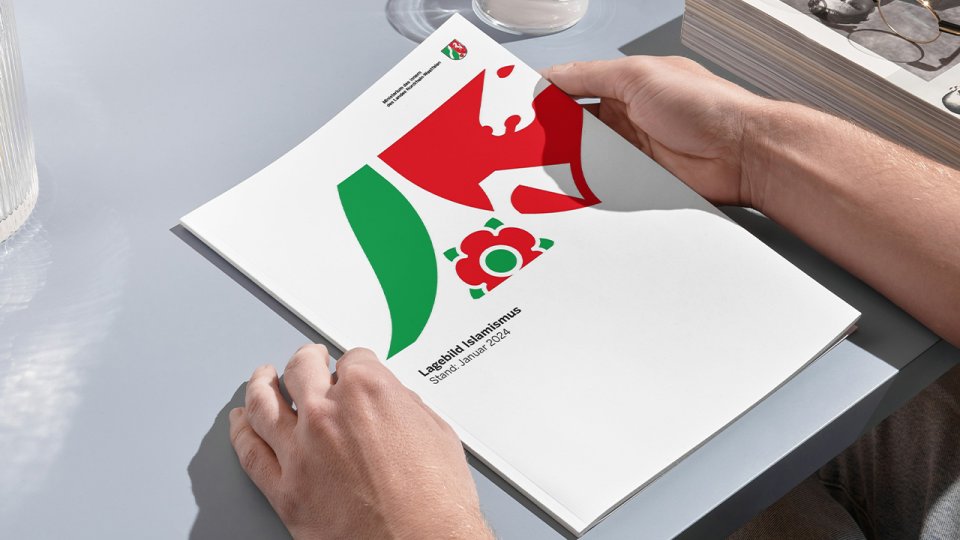 Bild von dem Lagebild Islamismus auf einem Schreibtisch umgeben von zwei Händen 