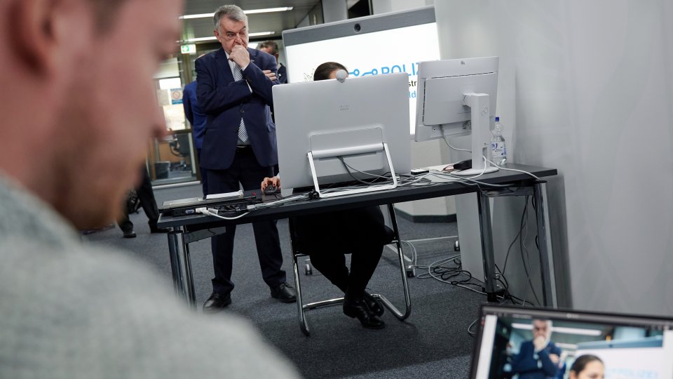 11.04.2022 Videovernehmung Polizeipräsidium Düsseldorf, Minister Reul mit Bearbeiterin hinter dem Bildschirm