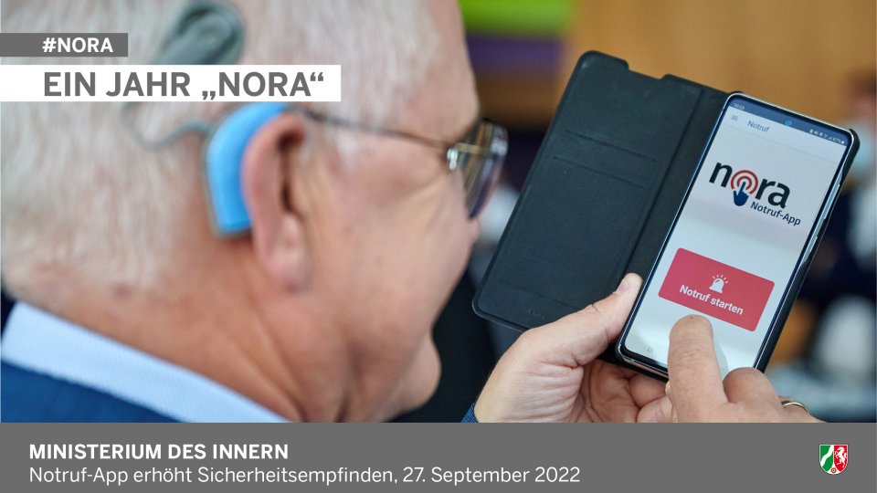 Notruf-App Nora. Mann hält Handy mit Nora-App in der Hand. Text: Ein Jahr Nora. Notruf-App erhöht Sicherheitsempfinden, 27. September 2022