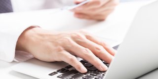 E-Rechnung, Hand an Laptop