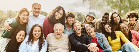 Eine Gruppe von M enschen sitzt gemeinsam auf der Wiese