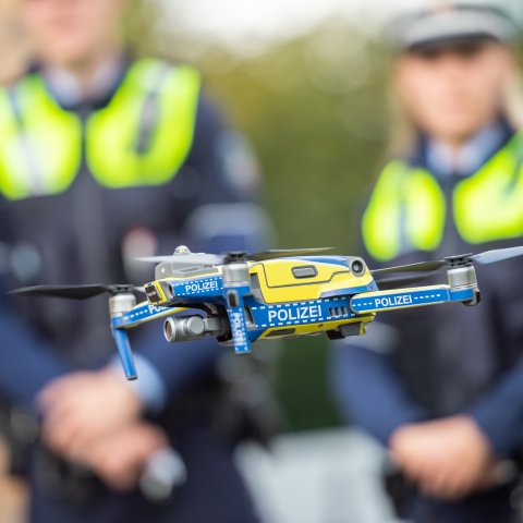 Einführung Drohnen Polizei NRW - Flug Drohne mit Polizisten im Hntergrund